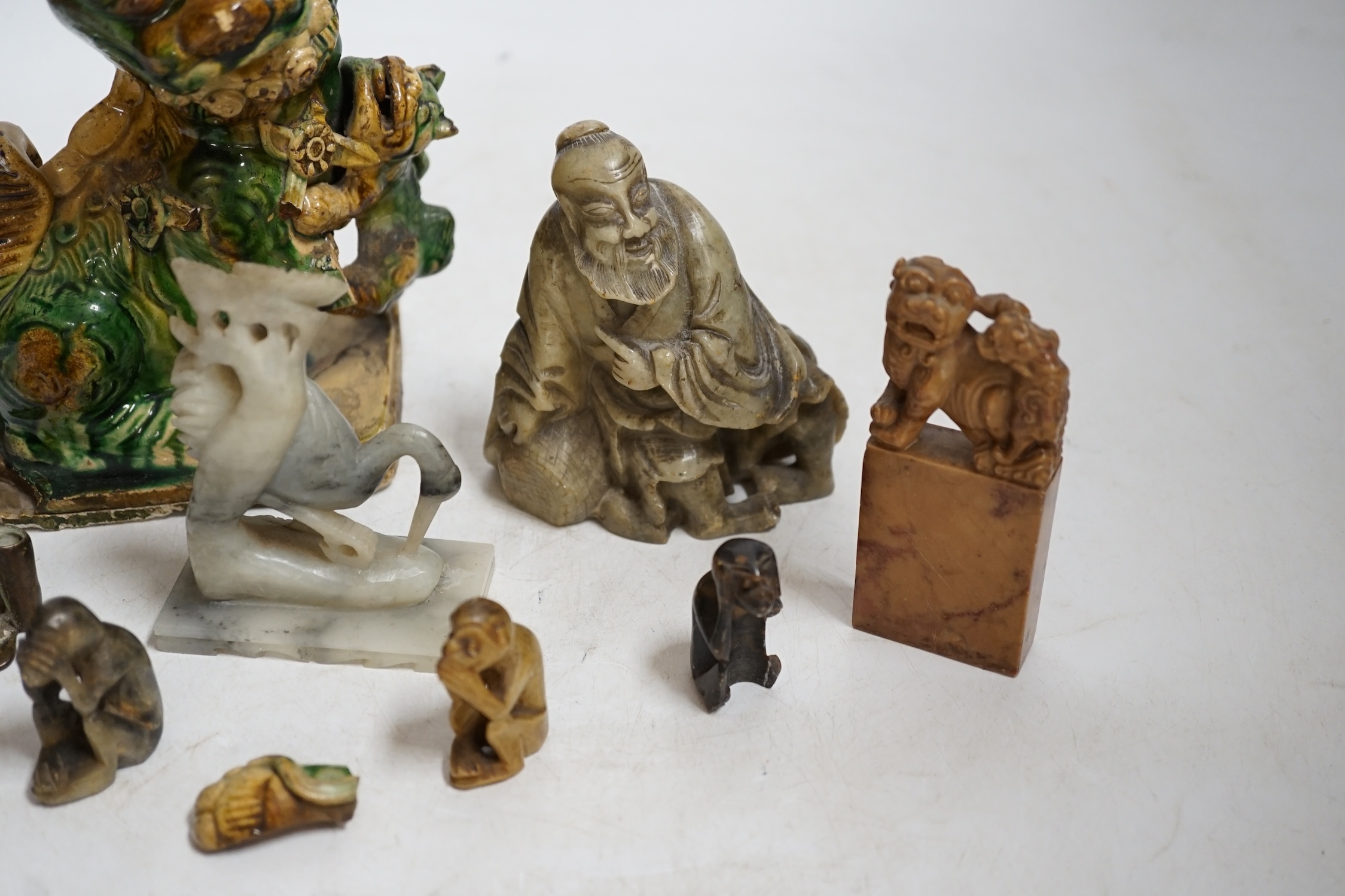 A glazed Chinese lion dog and a collection of soapstone carvings including seals, largest 17cm high. Condition - varies, poor to fair
